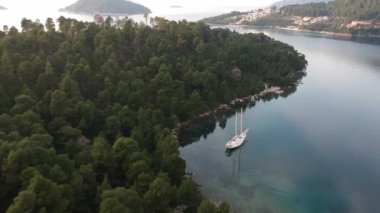 Küçük, pitoresk bir limanda demirli ahşap bir yelkenlinin hava manzarası. Yunanistan 'ın Zelos şehrinin inanılmaz güzelliği