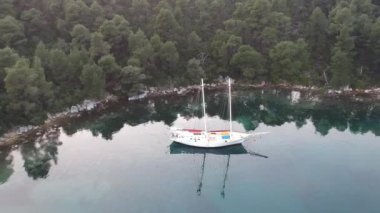 Küçük, pitoresk bir limanda demirli ahşap bir yelkenlinin hava manzarası. Yunanistan 'ın Zelos şehrinin inanılmaz güzelliği