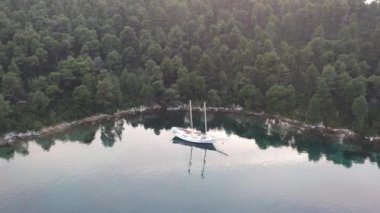 Küçük, pitoresk bir limanda demirli ahşap bir yelkenlinin hava manzarası. Yunanistan 'ın Zelos şehrinin inanılmaz güzelliği