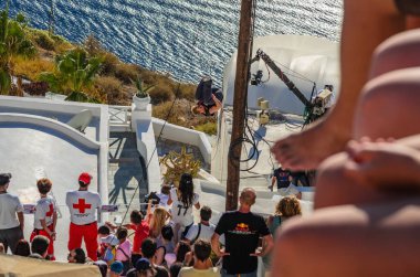 SANTORINI, GREECE - Eylül 2013: Parkour Athletes iş başında. Turistler ve ziyaretçiler, Yunanistan 'ın Santorini Adası' ndaki sporculardan eşsiz bir parkur gösterisi izlemek için bekliyorlar. Santorini, Cyclades, Yunanistan 'da halka açık gösteri için ücretsiz