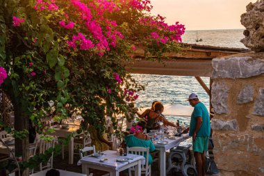 Turist ve ziyaretçiler, Yunanistan 'ın Laconia kentindeki Limeni kentinde geleneksel evleri ve renkli taşlı binalarıyla ünlü bir kıyı kasabası olan Limeni köyüne geldiler.