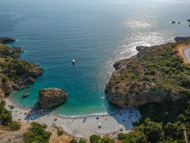 Yüksek turistik yaz döneminde Messenian Mani bölgesindeki Kardamyli köyü yakınlarındaki ünlü kayalık sahil Foneas 'ın hava manzarası. Messenia, Moreloponnese, Yunanistan.
