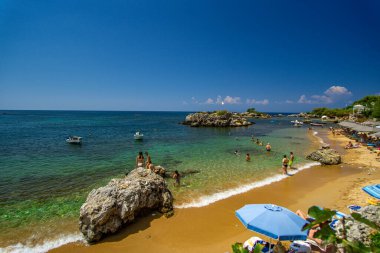 Turist ve ziyaretçiler, Yunanistan 'ın Messinia kentindeki Kardamili bölgesi yakınlarındaki Stoupa kumsalında yazın keyfini çıkarıyorlar.