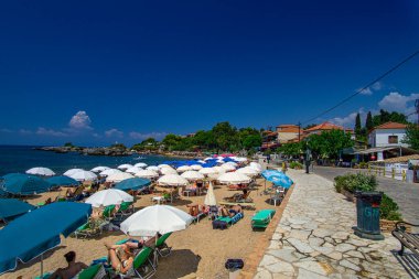 Turist ve ziyaretçiler, Yunanistan 'ın Messinia kentindeki Kardamili bölgesi yakınlarındaki Stoupa kumsalında yazın keyfini çıkarıyorlar.