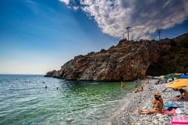 Foneas plajının panoramik manzarası turist ve yüzücülerle doludur. Kayalık plaj Yunanistan 'ın Messenia kentindeki Kardamyli köyü yakınlarındaki Mani kıyı bölgesinde yer almaktadır.