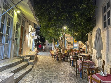 Geceleri Hydra adasının yaya sokakları. Turistler Yunan adasındaki yaşam ve atmosferin tadını çıkarırken Hydra 'nın merkezinin manzarası