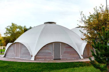 Çatıda tahta giriş kapıları olan bir kubbe şeklinde kumaş çadırlı yaz kafesi. Yaz Tatil Yeri