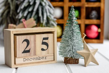 Arka planda çelenkler ve Noel ağaçları olan açık ahşap bir masada çok renkli Noel süslemeleri. Tatil için hazırlanıyor.