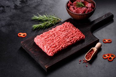 Karanlık bir arka planda taze çiğ et kıyması. Pirzola pişirme hazırlığı