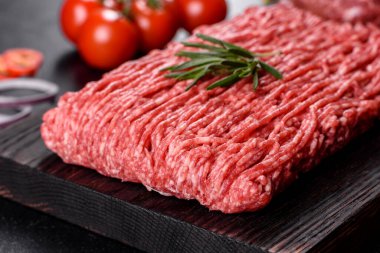 Karanlık bir arka planda taze çiğ et kıyması. Pirzola pişirme hazırlığı