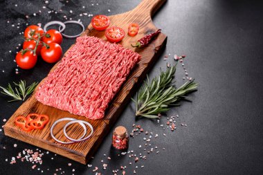 Karanlık bir arka planda taze çiğ et kıyması. Pirzola pişirme hazırlığı