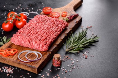 Karanlık bir arka planda taze çiğ et kıyması. Pirzola pişirme hazırlığı