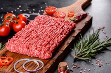 Karanlık bir arka planda taze çiğ et kıyması. Pirzola pişirme hazırlığı