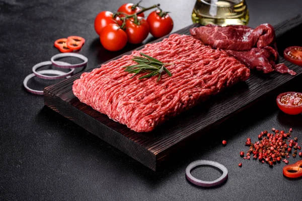 Karanlık bir arka planda taze çiğ et kıyması. Pirzola pişirme hazırlığı