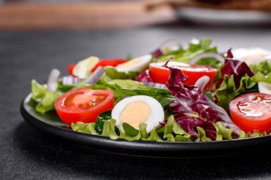 Koyu beton arka planda bir tabakta doğranmış sebze salatası.