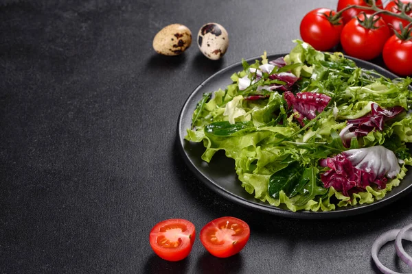 Koyu beton arka planda bir tabakta doğranmış sebze salatası.