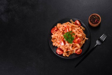 Esmer arka planda baharat ve otlarla domates soslu lezzetli taze macun. Akdeniz mutfağı