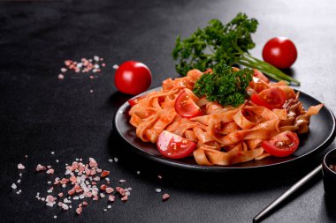 Esmer arka planda baharat ve otlarla domates soslu lezzetli taze macun. Akdeniz mutfağı