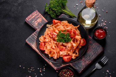 Esmer arka planda baharat ve otlarla domates soslu lezzetli taze macun. Akdeniz mutfağı