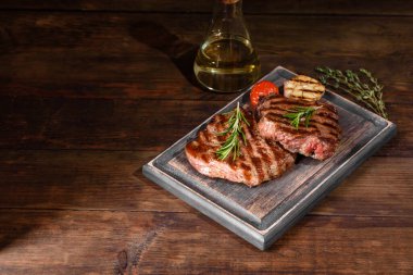 Karanlık bir arka planda taze sulu lezzetli biftek. Baharatlı ve otlu et yemeği.