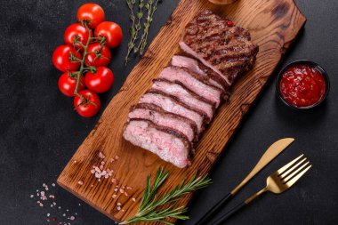 Karanlık bir arka planda taze sulu lezzetli biftek. Baharatlı ve otlu et yemeği.