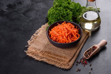 Lezzetli, sulu, parlak Kore havuçları seramik tabaklarda koyu beton arka planda. Asya mutfağı