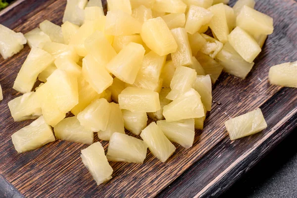 Pineapple canned with pieces on a wooden cutting board. Cooking Ingredients