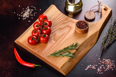 Koyu beton arka planda tuz, baharat ve otlarla tahta kesmek. Sağlıklı Yemek Pişirme