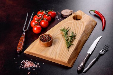 Koyu beton arka planda tuz, baharat ve otlarla tahta kesmek. Sağlıklı Yemek Pişirme