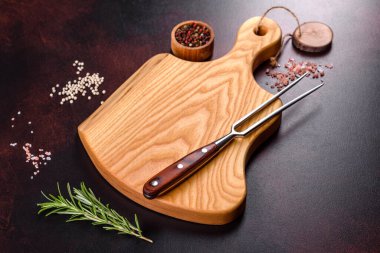 Koyu beton arka planda tuz, baharat ve otlarla tahta kesmek. Sağlıklı Yemek Pişirme