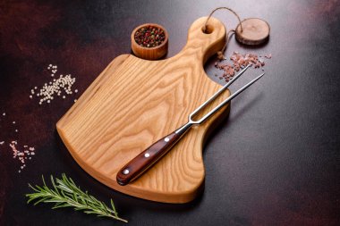 Koyu beton arka planda tuz, baharat ve otlarla tahta kesmek. Sağlıklı Yemek Pişirme