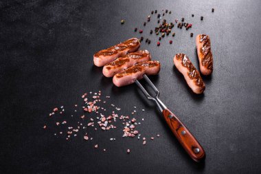 Sebze, baharat ve otlarla ızgara yapılmış lezzetli, taze sosisler. Bitmiş tabağın koyu beton bir masada fotoğrafı.