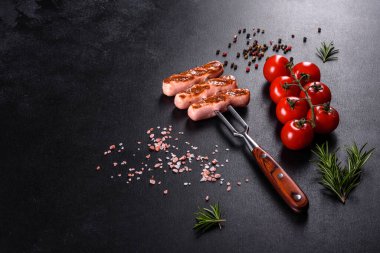 Sebze, baharat ve otlarla ızgara yapılmış lezzetli, taze sosisler. Bitmiş tabağın koyu beton bir masada fotoğrafı.