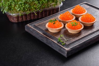 Koyu beton bir masada leziz taze kırmızı havyar. Lezzetli ve sağlıklı bir kahvaltı.