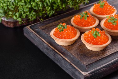 Koyu beton bir masada leziz taze kırmızı havyar. Lezzetli ve sağlıklı bir kahvaltı.