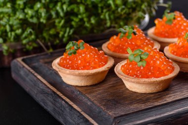 Koyu beton bir masada leziz taze kırmızı havyar. Lezzetli ve sağlıklı bir kahvaltı.