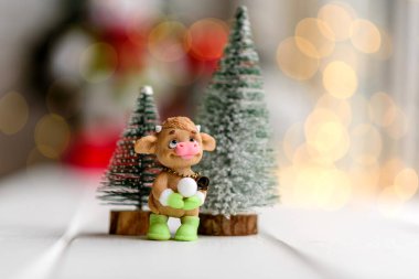 Arka planda çelenkler ve Noel ağaçları olan açık ahşap bir masada çok renkli Noel süslemeleri. Tatil için hazırlanıyor.