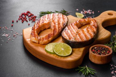 Taze pişirilmiş lezzetli somon bifteği, baharatlar ve ızgarada pişirilmiş otlar. Sağlıklı deniz ürünleri