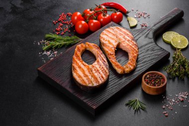 Taze pişirilmiş lezzetli somon bifteği, baharatlar ve ızgarada pişirilmiş otlar. Sağlıklı deniz ürünleri