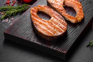 Taze pişirilmiş lezzetli somon bifteği, baharatlar ve ızgarada pişirilmiş otlar. Sağlıklı deniz ürünleri