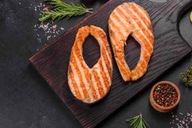 Taze pişirilmiş lezzetli somon bifteği, baharatlar ve ızgarada pişirilmiş otlar. Sağlıklı deniz ürünleri