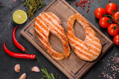 Taze pişirilmiş lezzetli somon bifteği, baharatlar ve ızgarada pişirilmiş otlar. Sağlıklı deniz ürünleri