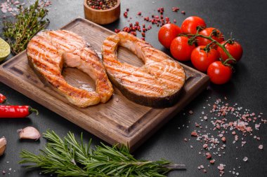 Taze pişirilmiş lezzetli somon bifteği, baharatlar ve ızgarada pişirilmiş otlar. Sağlıklı deniz ürünleri