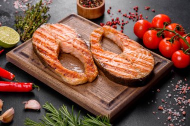 Taze pişirilmiş lezzetli somon bifteği, baharatlar ve ızgarada pişirilmiş otlar. Sağlıklı deniz ürünleri