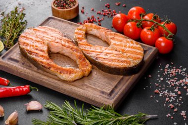 Taze pişirilmiş lezzetli somon bifteği, baharatlar ve ızgarada pişirilmiş otlar. Sağlıklı deniz ürünleri