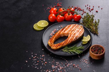 Taze pişirilmiş lezzetli somon bifteği, baharatlar ve ızgarada pişirilmiş otlar. Sağlıklı deniz ürünleri
