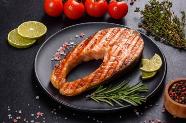 Taze pişirilmiş lezzetli somon bifteği, baharatlar ve ızgarada pişirilmiş otlar. Sağlıklı deniz ürünleri