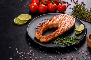 Taze pişirilmiş lezzetli somon bifteği, baharatlar ve ızgarada pişirilmiş otlar. Sağlıklı deniz ürünleri