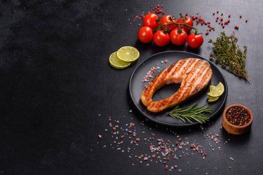 Taze pişirilmiş lezzetli somon bifteği, baharatlar ve ızgarada pişirilmiş otlar. Sağlıklı deniz ürünleri
