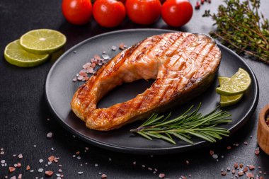 Taze pişirilmiş lezzetli somon bifteği, baharatlar ve ızgarada pişirilmiş otlar. Sağlıklı deniz ürünleri